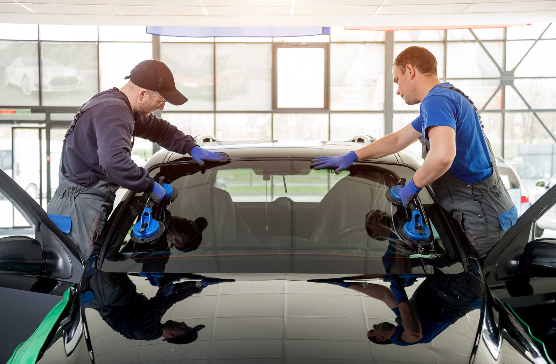 technician installing a windshield of a car